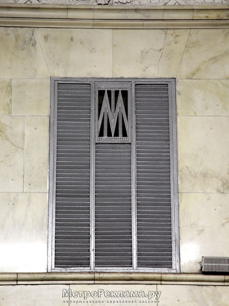 Станция "Автозаводская". Станционный зал. В верхней части путевых стен расположены жалюзи воздуховодов со стилизованной буквой "М". 