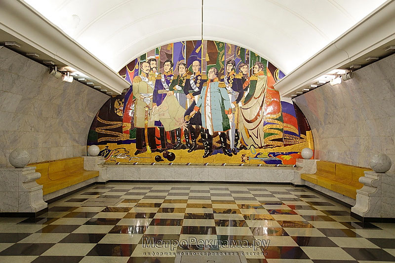 Станция метро "Парк Победы". Южный станционный зал. На торцевой стене расположено мозаичное панно, справой и левой стороны от которого установлены живописный скамьи для пассажиров.